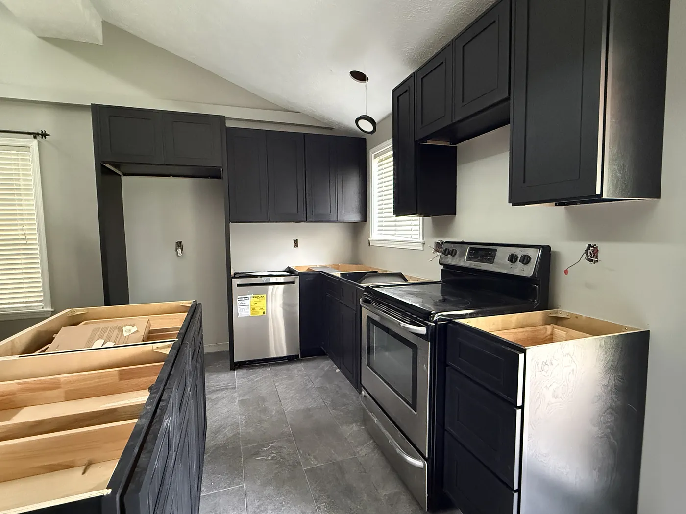 New dark cabinet boxes installed along the galley run with bare plywood tops, before the counters went on.
