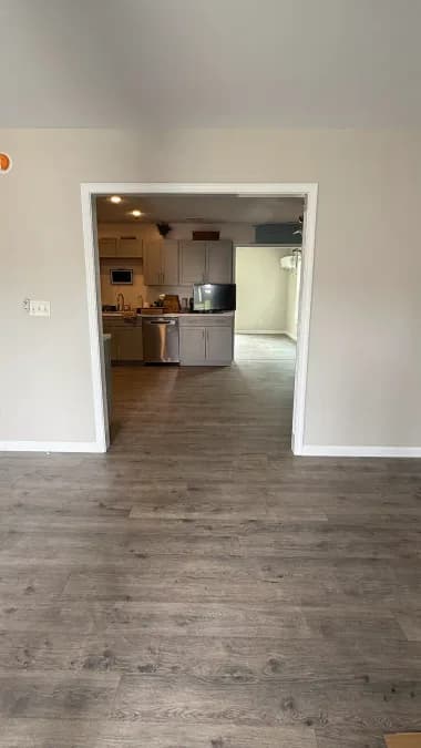 Finished ceiling, painted walls, white doorway trim, and plank flooring in the same area.