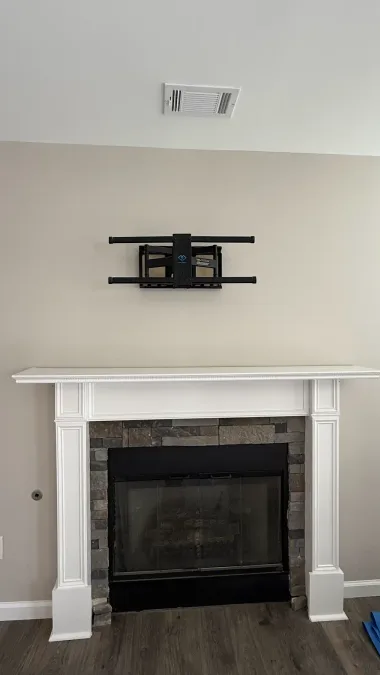 Fireplace wall and ceiling after repairs, with white mantel and surrounding flooring visible.